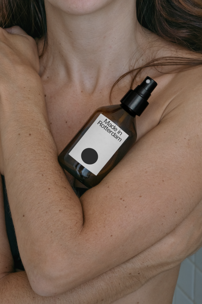 Close-up of a cosmetics bottle mockup held by a woman, clear label design ready for branding, ideal for beauty and skincare templates.